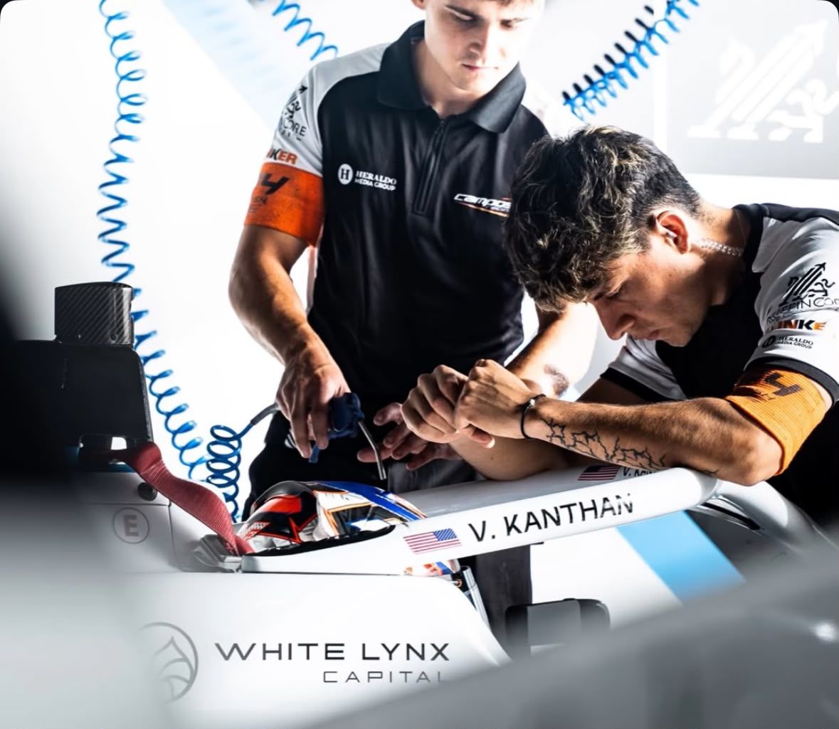 Two mechanics working on the cockpit of the number 22 Formula 4 car