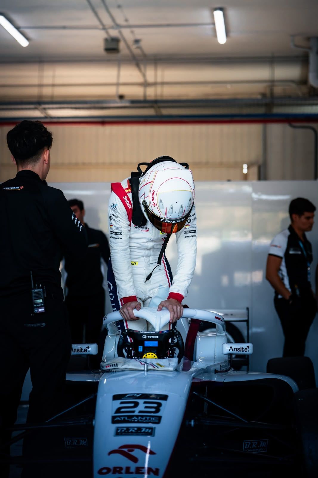Driver climbing out of the number 23 car in the garage