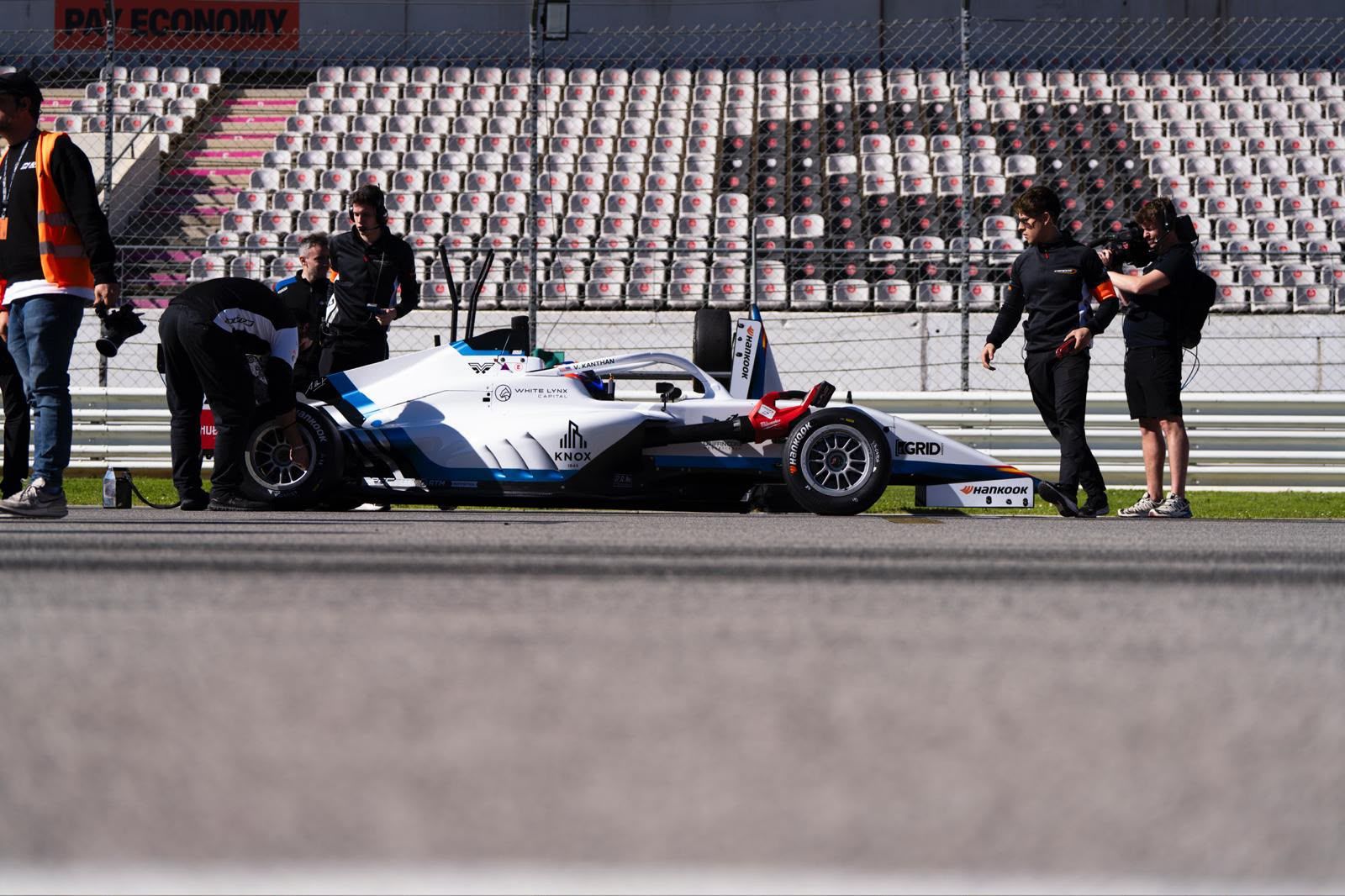 Bryan crouching next to the number 22 car on the starting grid
