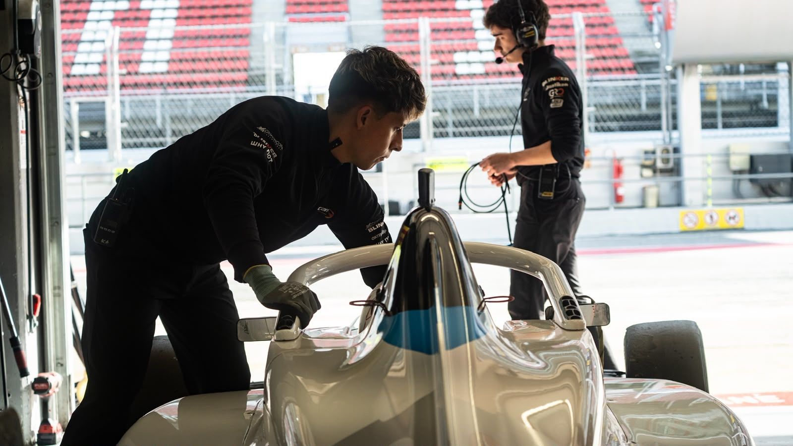 Bryan Ronquillo leaning over a Formula 4 car in the Campos Racing garage