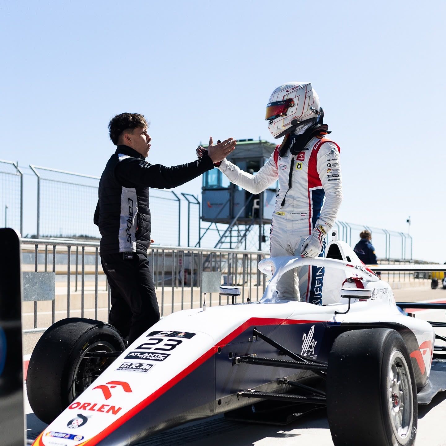 Bryan high-fiving his driver standing on the car after a race